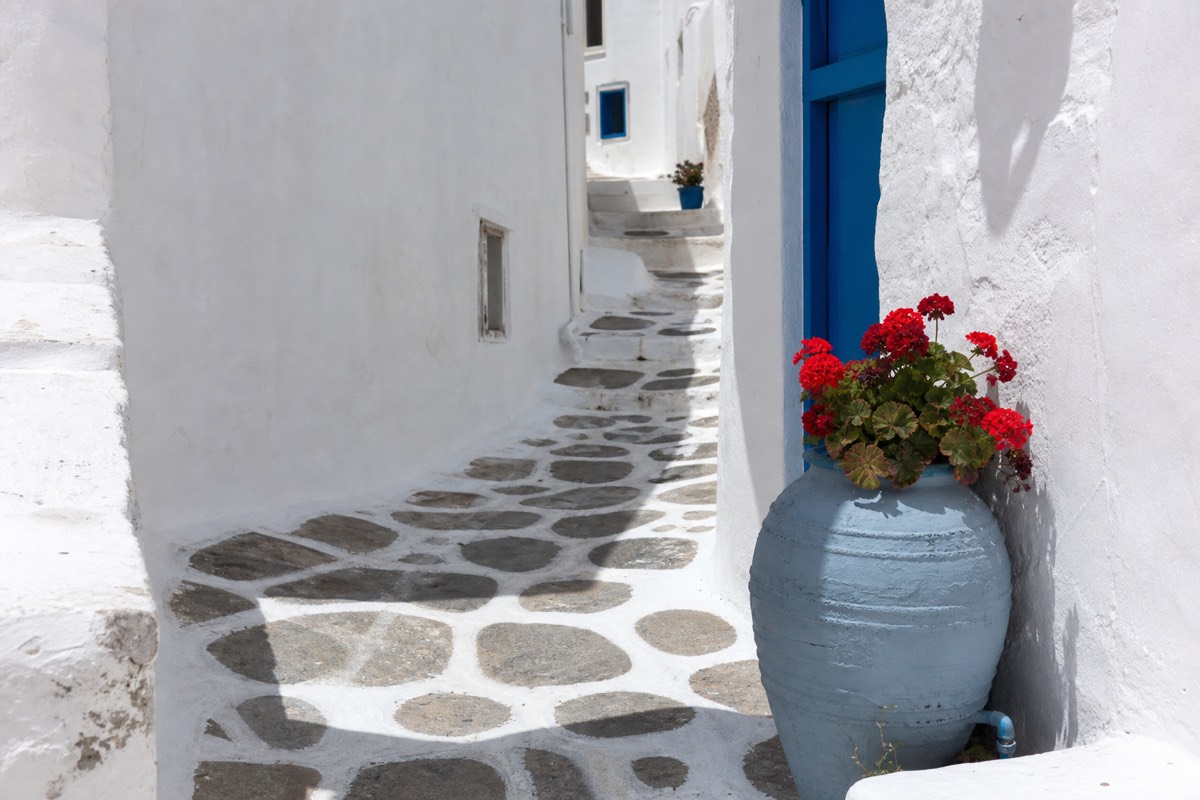 A near-empty whitewashed island lane showing the quiet side of visiting Greece in the winter off-season